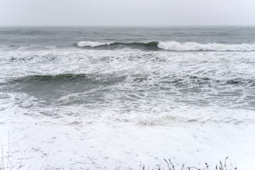 Tasman sea waves and froth on shore at Woodpecker bay, near Tiromoana, West Coast, New Zealand