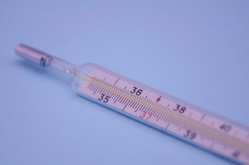 Mercury thermometer  on a blue background. the concept virus Covid-19. Coronavirus.