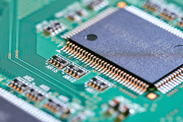 Electronic circuit board with electronic components such as chips close up. Blurry background.	