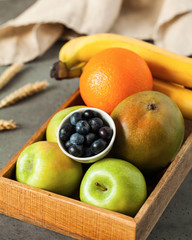  Fresh fruits and blueberries in a wooden box. Food photo for eco-markets, health food stores, vegetarians.