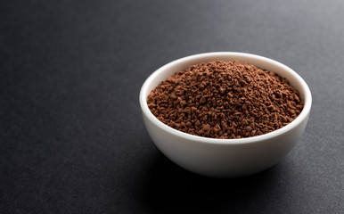 Pile of cocoa powder on black background