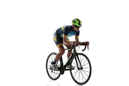 Triathlon Male Athlete Cycle Training Isolated On White Studio Background. Caucasian Fit Triathlete Practicing In Cycling Wearing Sports Equipment. Concept Of Healthy Lifestyle, Sport, Action, Motion.