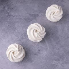 delicate white marshmallows in a minimal composition on a gray background