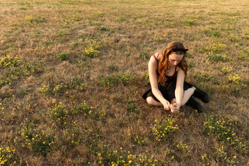 Girl sitting in a field of wildflowers