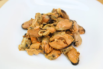  salad of seafood, mussels, raps, squids, on a white plate on a wooden background
