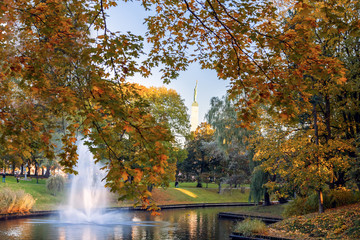 Golden autumn in the city park of Riga with canal and fountain. Riga, Latvia.