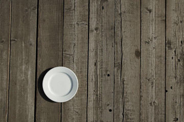 white plate stands on a wooden floor