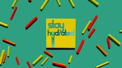 stay hydrated yellow post it paper and green background 