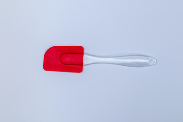 Red pladstic spatula tool kitchenware on white background.
