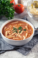 Tomato soup with fusilli pasta in the bowl