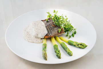 Hake with black pepper sauce accompanied by asparagus