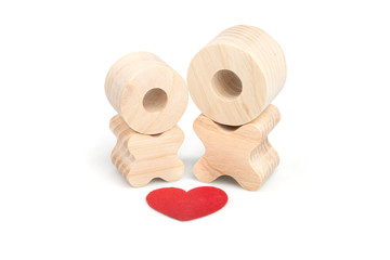 Two wooden figures and a red heart above them. The concept of love and romance. Couple in love. Lovers.
