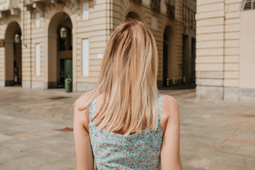 A beautiful woman with blond hair walks through the streets of the city. Girl enjoy holidays in Europe. Beautiful historical architecture. Italian weekend. Travel to Turin, Italy. Adventure lifestyle