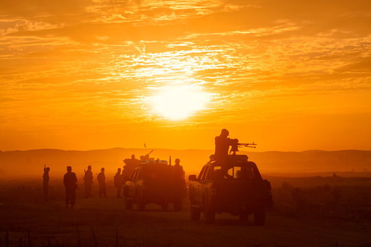 silhouettes of policemen in front of sunset