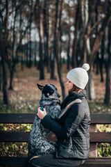 Fototapeta premium A girl is holding a mongrel dog in her arms. Caring for animals.