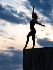 Young woman dancer on outdoor sunrise background. Concept of freedom and happy lifestyle