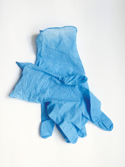 Aerial view of disposable surgical gloves in blue latex, thin to the touch and resistant isolated on white background. Protection against harmful substances, viruses and food handling.