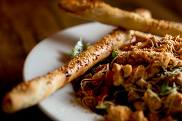Chicken salad with rocket, cherry tomatoes, smoked cheese and crunchy sesame sticks
