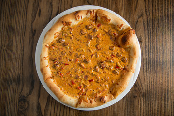 Pizza with cheese and beefsteak in mushroom sauce