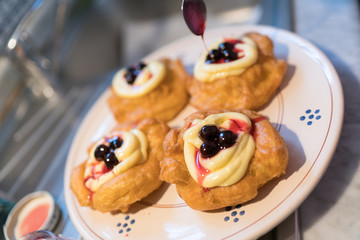 The Neapolitan pastry is called zeppola di san giuseppe, with black cherries, lemon cream with vanilla - Street Food Naples - Italy
