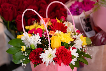 bouquet of colorful flowers in a pink basket.