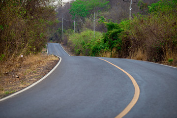 Close-up view of the road that passes through the canyon in the summer, there is a change of forest color and there is no heavy traffic which is convenient for traveling.