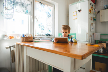 Young Boy looking at digital tablet, staying at home