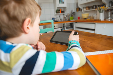 Young Boy looking at digital tablet, staying at home