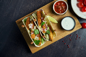 Appetizing Mexican tacos with fried chicken, cabbage, onions and parsley in special stands. Traditional mexican cuisine