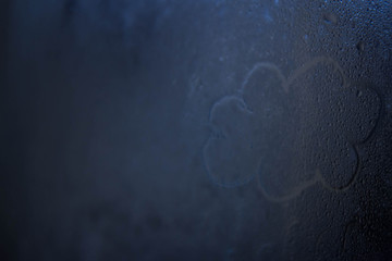 Wet and warm weather. Raw glass, raindrops, image of a cloud.