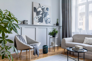 Stylish scandinavian home interior of living room with design gray sofa, armchair, marble stool,...