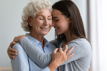Supportive mature mother hug cuddle grown-up daughter show love and care, happy smiling elderly mom...
