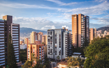 Fototapeta na wymiar The sun goes down over the skyscraper apartments of the affluent barrio of El Poblado in the city of Medellin, Colombia