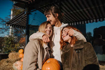 Girls holds pumpkins in hands. Outdoor photo.