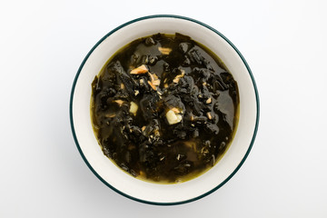 Seaweed soup in a bowl on a white background