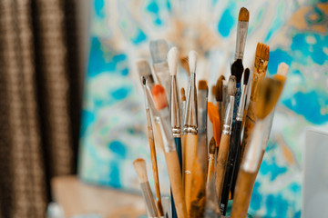 Obraz premium Tools and equipment for the artist. Palette and brushes close-up. The process of drawing and creativity. The picture is in blue.