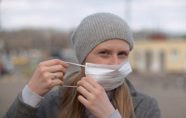 Handsome woman puts on protective mask