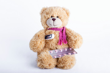 Children's soft toy teddy bear with pills and thermometer. Child' disease. Pediatrics concept.