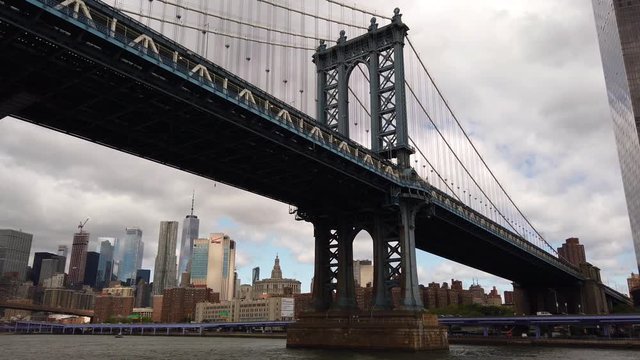 Establishing shot of the Manhattan bridge with the financial district in the background, filmed from the East River in motion