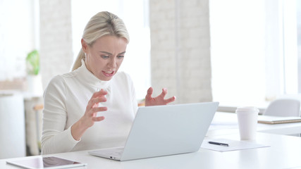 Angry Young Businesswoman working on Laptop