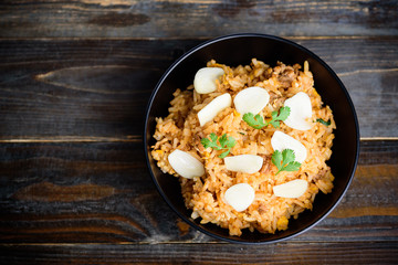 Fried rice with minced pork and fresh garlic in a bowl on wooden background, Asian food, Top view