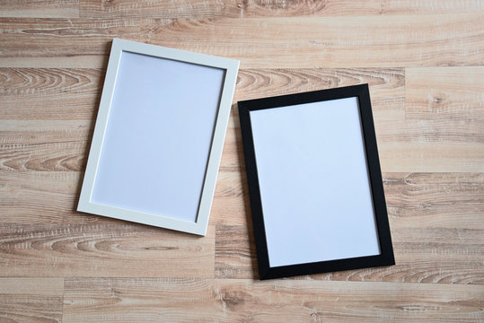 Top view of two photo frames on the wooden floor. Blank frame mockups.