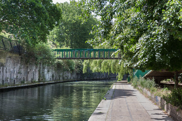 Fototapeta na wymiar Canal, Bridge and Pedestrian Path along the River Bank of Regent’s Canal in London