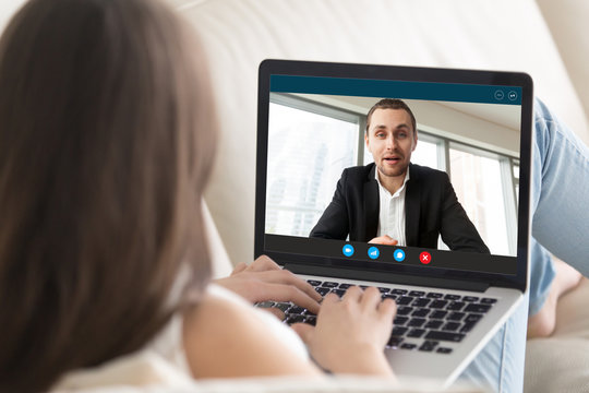 Young businesswoman talk chat with financial consultant on video call on laptop, female employee or client speak with male business partner use webcam computer conference, online consultation concept