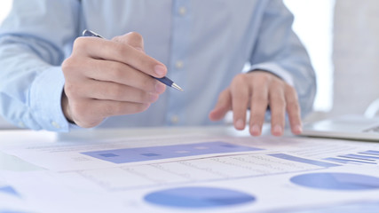 Close Up of Young Guy Hands checking Reports in Office