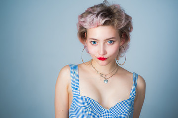 Retro model with pin up make up. Close up portrait of young beautiful woman with pinup style, hoop earrings, posing on gray Isolated background. Copy, empty space for text.