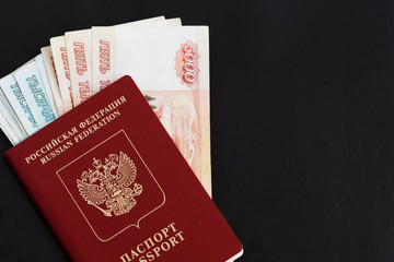 Russian foreign passport  on a black background. Copy space. Passport with money for travel.