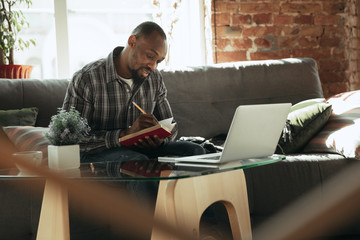 Checking to do list. Man, freelancer during the work in home office while quarantine. Young male...