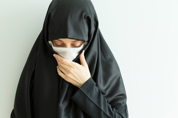 the woman wearing black clothes and hijab save body with mask from corona virus and illness.