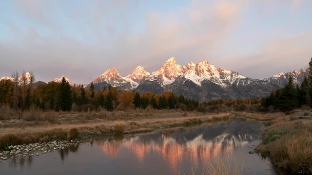 autumn sunrise view of grand teton and its reflection at schwabacher landing in grand teton national park at jackson hole, wyoming